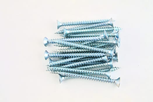 Screws for construction on a white background, metal screw, iron screw, chrome screw, screws as a background, wood screw. Close-up.