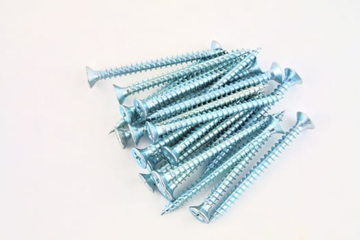 Screws for construction on a white background, metal screw, iron screw, chrome screw, screws as a background, wood screw. Close-up.