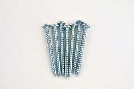 Screws for construction on a white background, metal screw, iron screw, chrome screw, screws as a background, wood screw. Close-up.