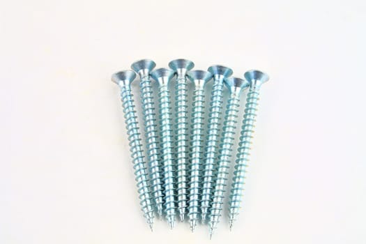 Screws for construction on a white background, metal screw, iron screw, chrome screw, screws as a background, wood screw. Close-up.