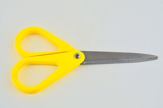 Yellow scissors isolated on a white background. Top view.