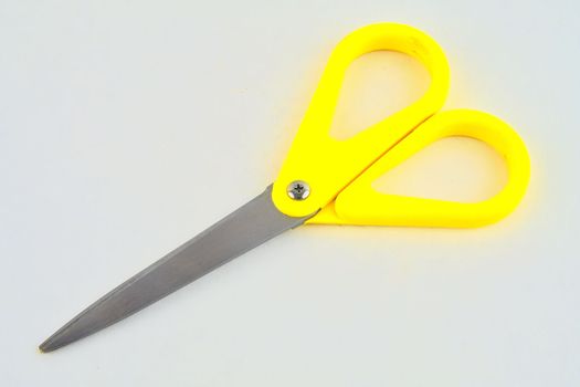 Yellow scissors isolated on a white background. Top view.