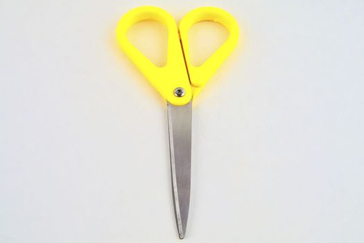 Yellow scissors isolated on a white background. Flat design. Top view.