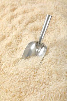 scoop of white long grained rice on rice background
