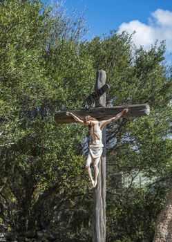 religious monument with jesus christ at the cross at the road on sardinia island italy