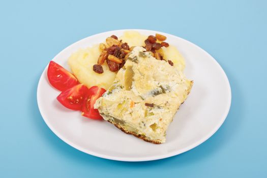 Baked leek with mashed potatoes on a blue background