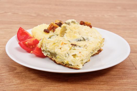 Baked leek with mashed potatoes on a wooden table