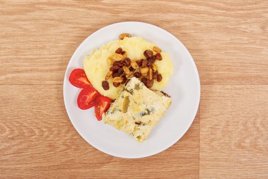 Baked leek with mashed potatoes on a wooden table