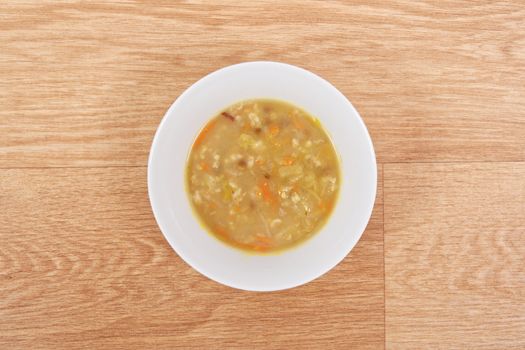 Soup with pasta and vegetables on a wooden table