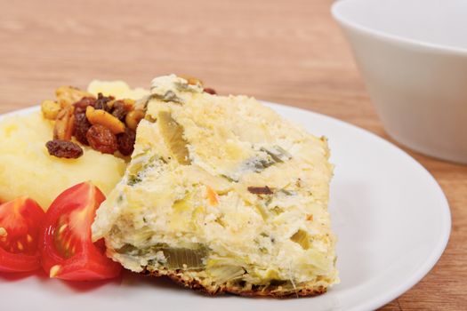 Baked leek with mashed potatoes on a wooden table