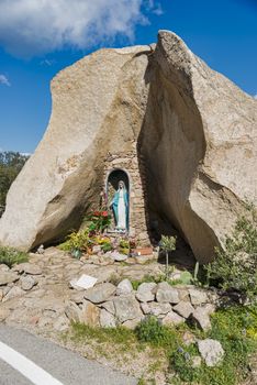 religious monument with the catholic statute of maria along the road on the italian island of sardinia