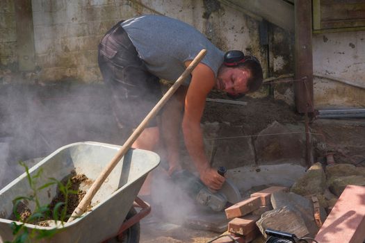 Worker cuts the bricks with a cut-off grinder.