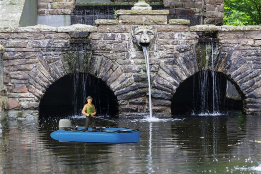 Miniature figure with dinghy for fishing in a moat