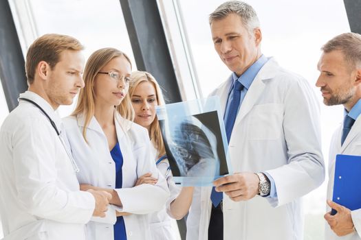 Group of doctors look and discuss x-ray in a clinic or hospital