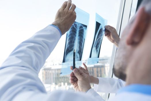 Group of doctors look and discuss x-ray in a clinic or hospital