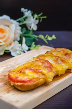 homemade French bread roll, topped with fresh tomatoes, melted cheddar, Mozzarella and Parmesan