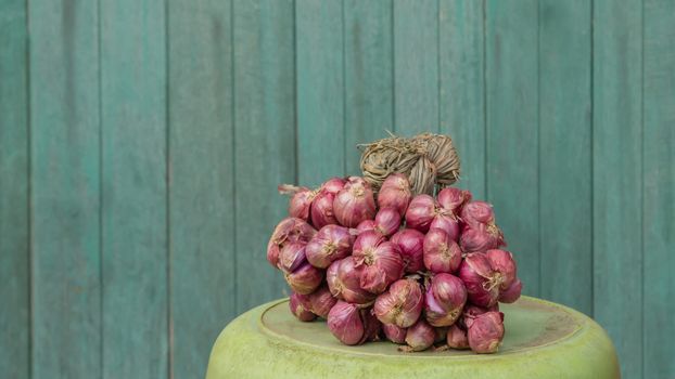 red shallot on plastic basin over old wood background