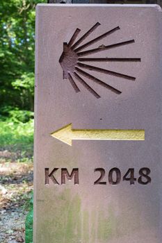 Milestone or signpost with arrow and jacobs shell