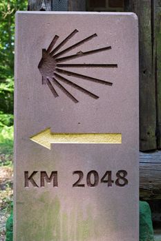 Milestone or signpost with arrow and jacobs shell