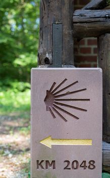 Milestone or signpost with arrow and jacobs shell