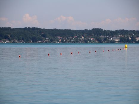 Line of Red Water Markers with One Big Yellow on Blue Lake with background