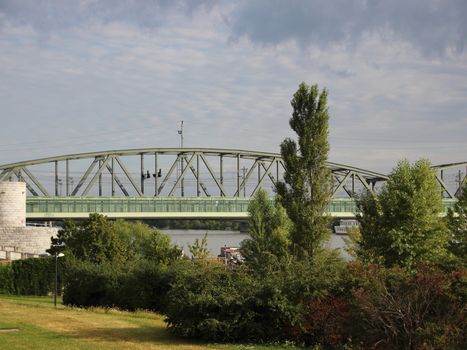 Green Metal Railroad Bridge in Vienna with Grass and Trees in Foreground