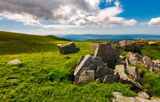 boulders on top of Runa mountain. beautiful landscape with distant peak under the cloud on a blue sky