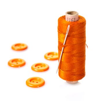 spool of thread and buttons on white isolated background