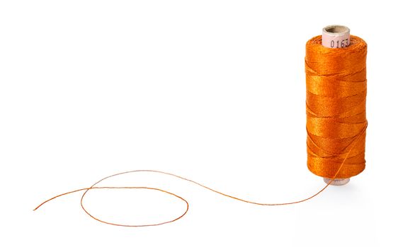spool of orange threads on a white isolated background