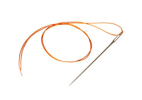 orange thread in a needle on a white isolated background