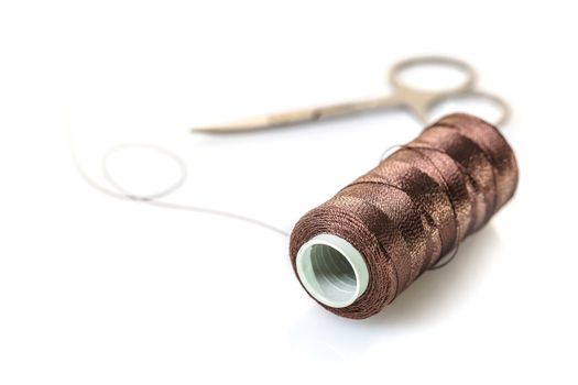 spool of brown threads on a white background