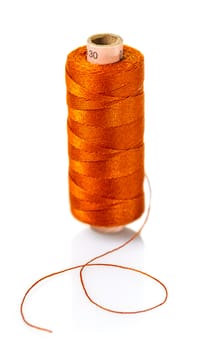 spool of orange threads on a white isolated background