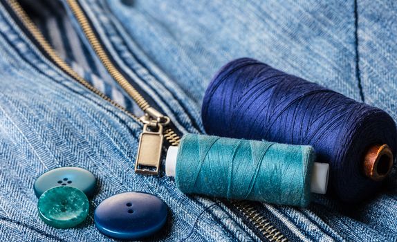 blue threads with buttons on the background of a denim jacket