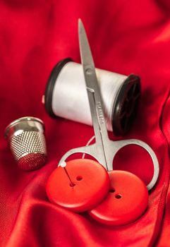 sewing accessories on a background of red fabric