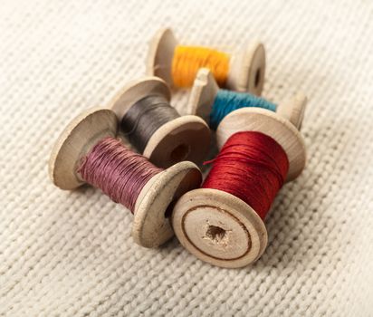 coils of colored thread on white knitted fabric