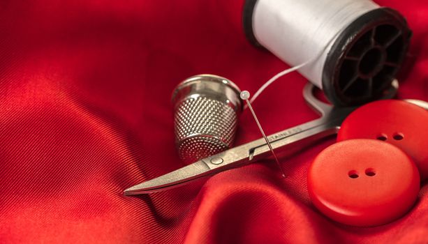 sewing accessories on a background of red fabric