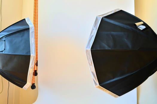 Empty photo studio with lighting equipment. White background in photo studio.