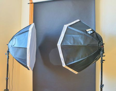 Empty photo studio with lighting equipment. Black background in photo studio.