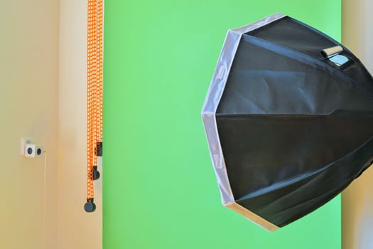 Empty photo studio with lighting equipment. Green background in photo studio.