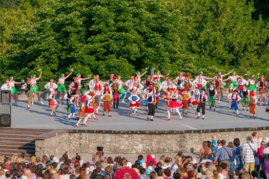 KIEV, UKRAINE - July 22 , 2016: Ukraina School of Dance Ensemble girls and boys dressed in traditional red Ukrainian embroidered costume clothes dancing