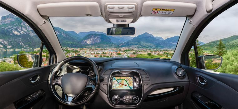 Looking through a car windshield with view over Riva del Garda, Lake Garda, Italy