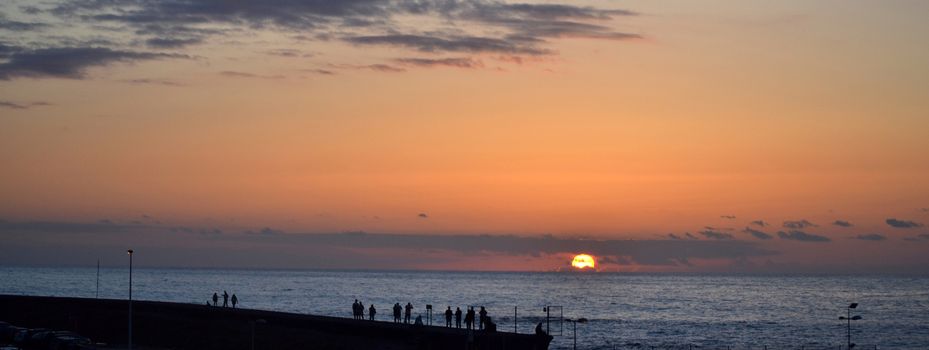 People watching the sunset on Atlantic Ocean shore