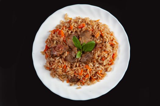 Plate with an asian food pilaw on a black studio background
