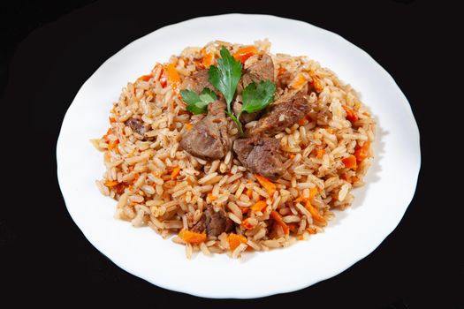 Plate with an asian food pilaw on a black studio background