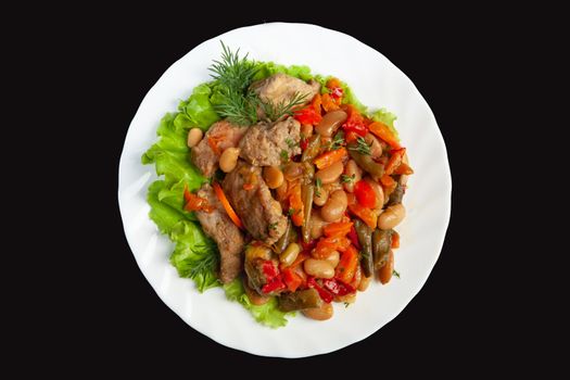 Porcelain plate with roasted meat and potatoes on a black studio background