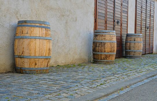 Old rustic wine barrels in front of modern wine cellar. Wine background in Europe. Czech Republic, South Moravia. 