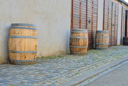 Old rustic wine barrels in front of modern wine cellar. Wine background in Europe. Czech Republic, South Moravia. 