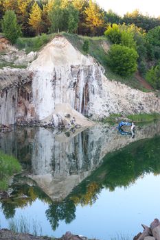 Basalt columns landscape rock quarry. Beautiful stone landscape and submerged excavator in water