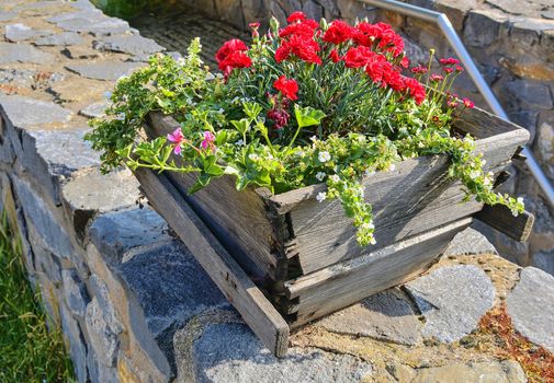 Old rustic wooden window box. Flowery background in Europe. Czech Republic, South Moravia. 