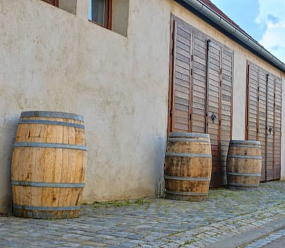 Old rustic wine barrels in front of modern wine cellar. Wine background in Europe. Czech Republic, South Moravia. 